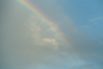 Rainbow with clouded blue sky background