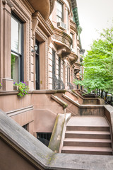 Fototapeta na wymiar Main ladder and entry door. New york Harlem buildings. Brown houses. NYC, USA.