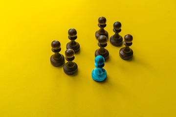 a unique chess pawn in color. leadership concept on a chessboard between other pieces.