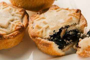 Broken off piece of mince pie with blueberry jam filling
