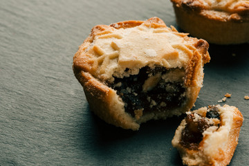 Traditional mince pie with broken off piece near it