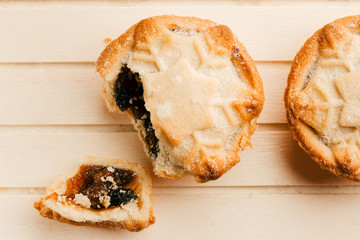 Top view of traditional British Christmas pies on wooden board