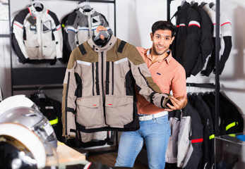 Male customer is demonstrating modern jacket that he choose