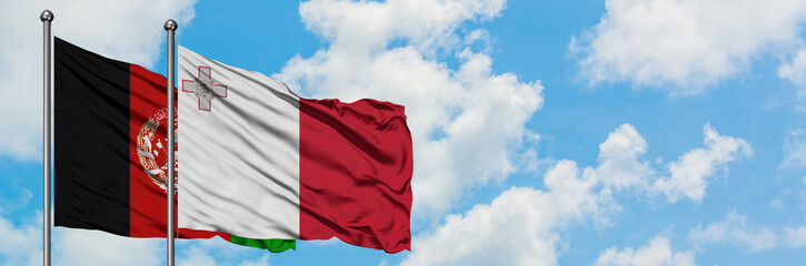 Afghanistan and Malta flag waving in the wind against white cloudy blue sky together. Diplomacy concept, international relations.