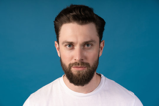 Casually handsome. Confident young handsome man standing against blue background.