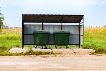 Obraz premium Two green dumpsters on the street under a canopy. Garbage reform in Russia.