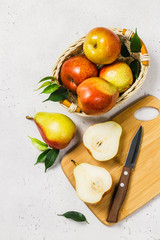 Ripe colourful pears sliced on cutting board. Top view, space for text.