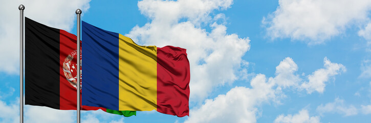 Afghanistan and Romania flag waving in the wind against white cloudy blue sky together. Diplomacy concept, international relations.