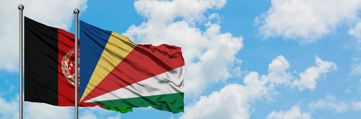 Afghanistan and Seychelles flag waving in the wind against white cloudy blue sky together. Diplomacy concept, international relations.