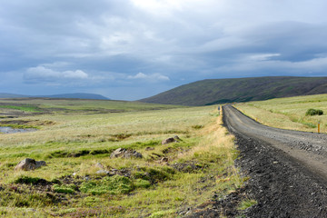 Fototapeta na wymiar On the road in Iceland with rocks and cloudy landscape, Iceland, Europe.