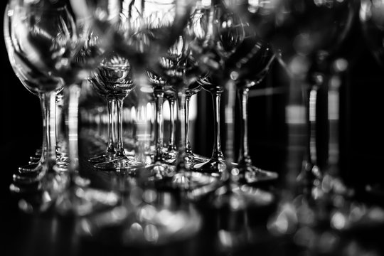 empty wine glasses. Beautiful new glasses for wine from glass stand in even rows on a wooden table in a restaurant. selective focus