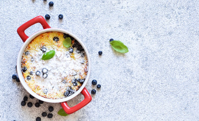 Dessert on a stone white background. Vanilla Pudding with Blueberries. View from above.