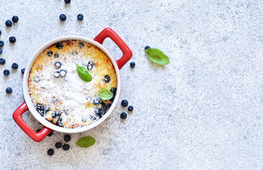 Dessert on a stone white background. Vanilla Pudding with Blueberries. View from above.