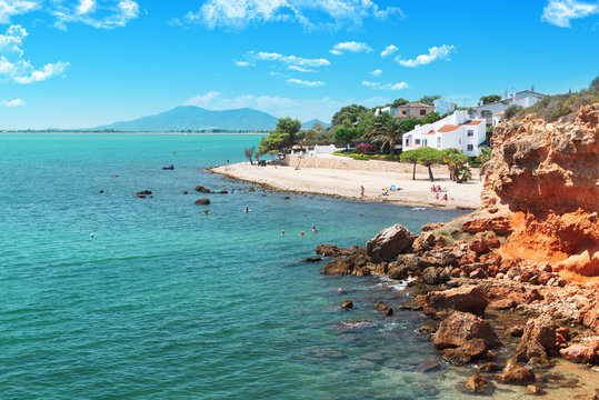 Bacone Cove in Ampolla touristic village near Tarragona, Catalonia. Beach tourism in Mediterranean side of Spain with empty copy space for Editor's text.