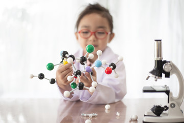 Young scientist girl holding the molecular structure to do science 