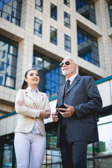 An older man and a young colleague are talking about work