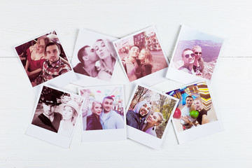 Printed photos in a loving couple from different places. Pleasant travel memories. The concept of a happy relationship.