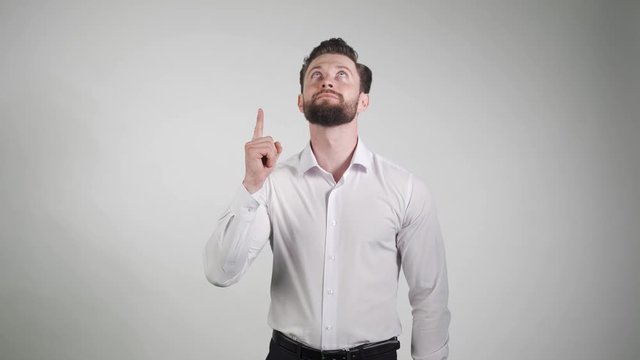 2 in 1. A young man showing something isolated on white background. Firstly pointing and looking up. Secondly pointing up and smiling.