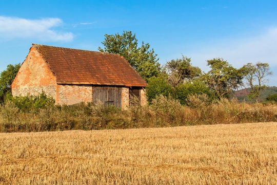 Old agricultural barn in the Czech Republic. Harvested field. Morning on the farm.