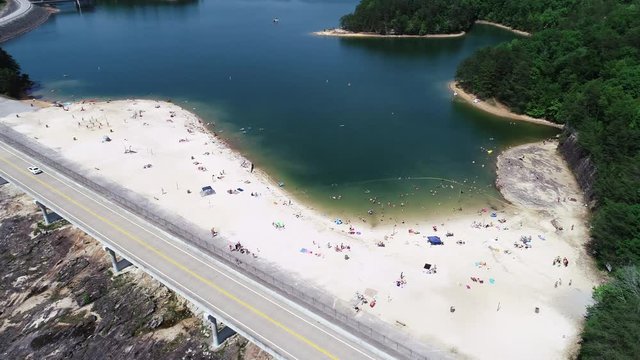 Panning aerial, people on beach in Laurel River Lake