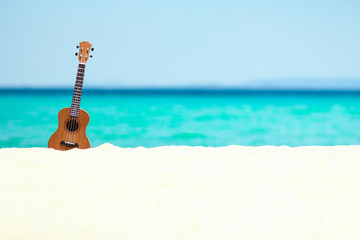 ukulele on the sand by the sea in summer