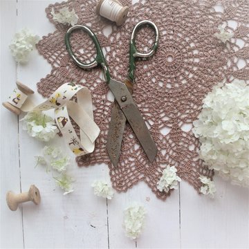 A crocheted doily on white background. Goods for needlework. The concept of tenderness, gift, hobby. Vintage style.