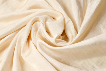 Soft smooth beige silk fabric background. Fabric texture.