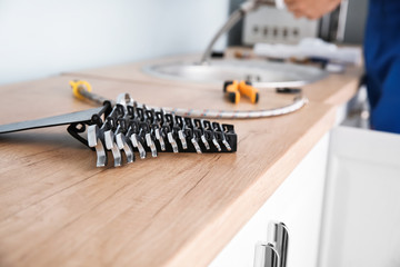 Set of wrenches and plumber tools on kitchen counter