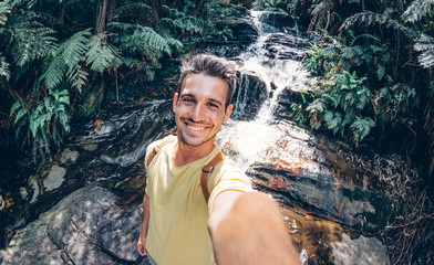 Happy young man take a selfie on a excursion in the forest at summe