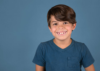 Handsome happy smiling boy in blue shirt isolated on blue background - 285533919
