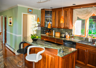 Stylish kitchen wooden interior with island table with two chairs beside.