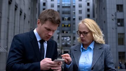 Male assistant making to do list smartphone application, sending business email