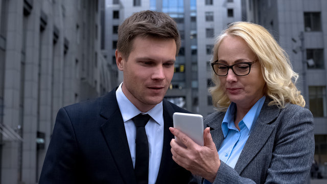 Company brokers using stock trading application by smartphone, business gadget