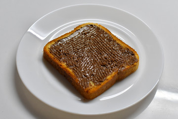 Chocolate cream spread on a toast bread loaf
