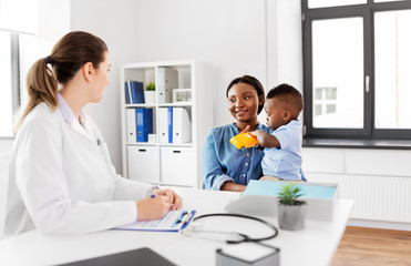 Fototapeta premium medicine, healthcare and pediatry concept - happy african american mother with baby son and caucasian doctor at clinic