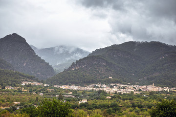 View of a small village with mountains in the fog as a background. Mallorca, Spain