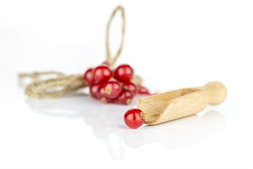 Lot of whole fresh red currant with wooden scoop and jute rope isolated on white background