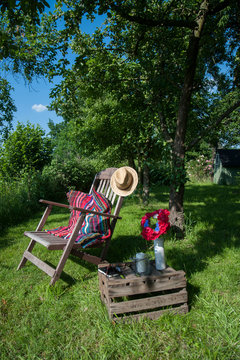 Cushion made of patchwork rug on deckchair in the garden
