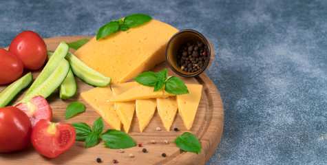 Dutch cheese with cucumbers and tomatoes and basil on a blue background