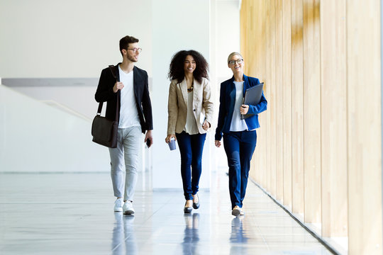 Young business people walking and talking in a hallway