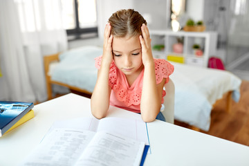 children, education and learning concept - sad student girl with notebook at home