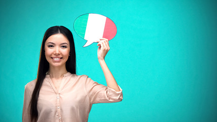 Smiling girl holding Italian flag speech bubble, learning language, travel ideas