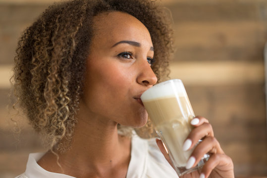 Young woman drinking Latte Macchiato