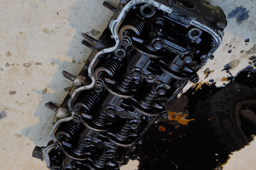 The head of the block of cylinders. The head of the block of cylinders removed from the engine for repair. Parts in engine oil. Car engine repair in the service