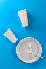 White plastic dishes on a blue background.