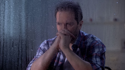 Hopeless man thinking about life and health problems on rainy day, depression