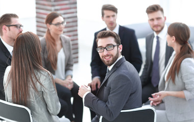 young employee sitting in a circle of colleagues