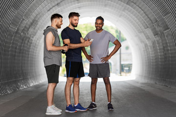 fitness, sport and healthy lifestyle concept - smiling young men or male friends with smartphone...