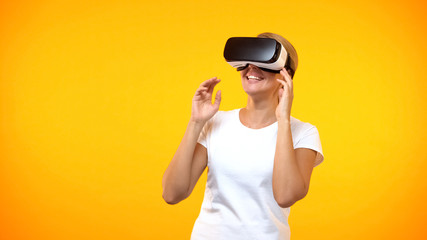 Happy female gamer wearing virtual reality headset, modern technology cyberspace