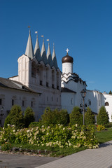 Fototapeta premium The belfry and the Church of the Protection of the Holy Virgin in Tikhvin Assumption (Assumption) monastery. Tikhvin, Russia